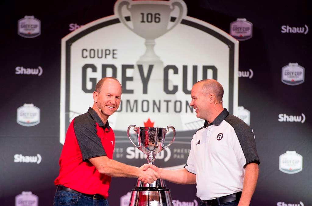 Calgary Stampeders head coach Dave Dickenson, left, and Ottawa Redblacks head coach Rick Campbell, right, arrive for the head coaches news conference in Edmonton, Alta. Wednesday, Nov. 21, 2018. The 106th Grey Cup will be played Sunday between the Ottawa Redblacks and the Calgary Stampeders.