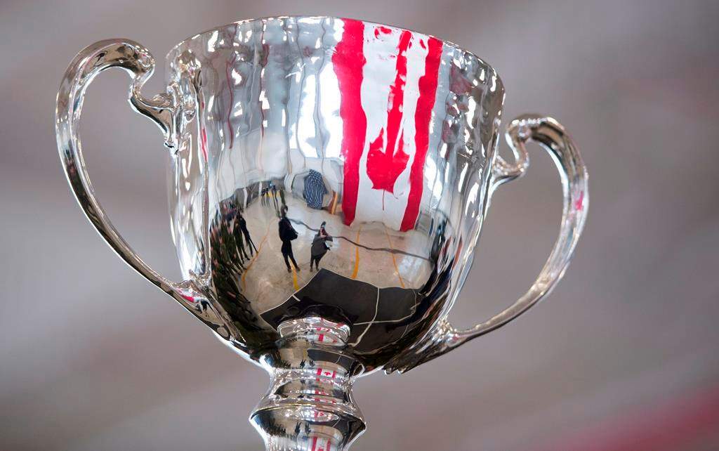 The Canadian flag is reflected in the Grey Cup as it arrives at Canadian Forces Base in Edmonton, Alta., Tuesday, Nov. 20, 2018. The 106th Grey Cup will be played Sunday between the Ottawa Redblacks and the Calgary Stampeders.