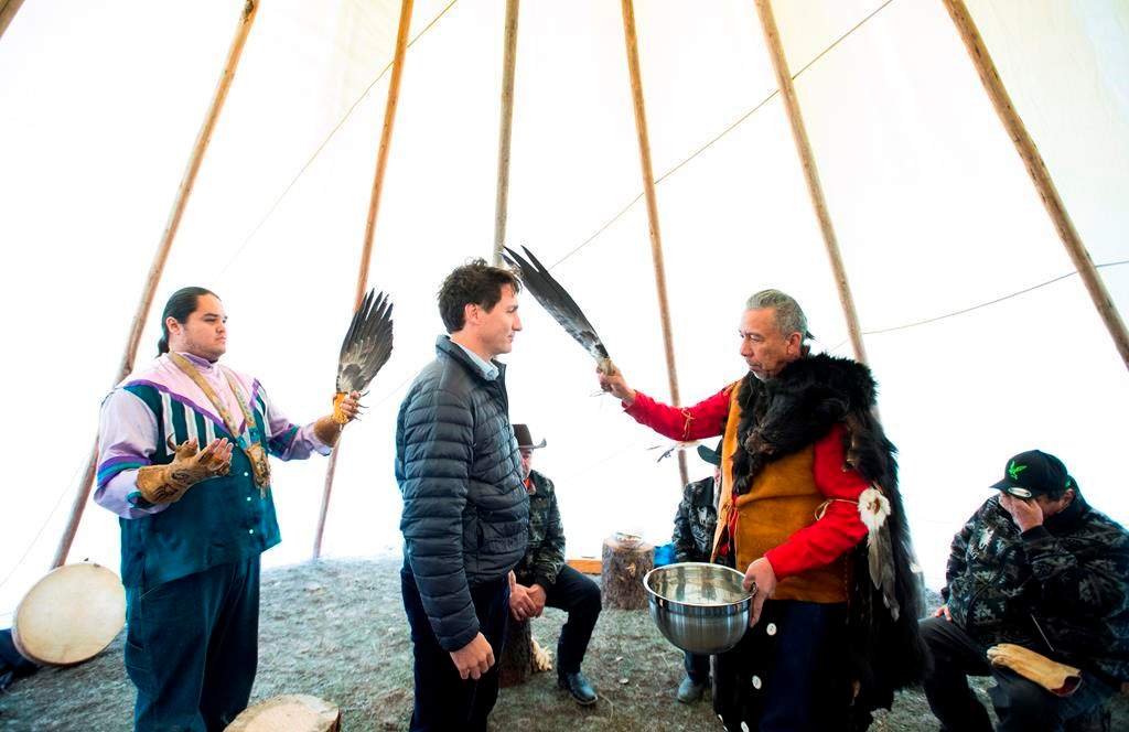 Prime Minister Justin Trudeau receives a water cleansing by spiritual leader Cecil Grinder along with Chiefs of the Tsilhqot'in National Government near Chilko Lake, B.C., Friday, Nov. 2, 2018.