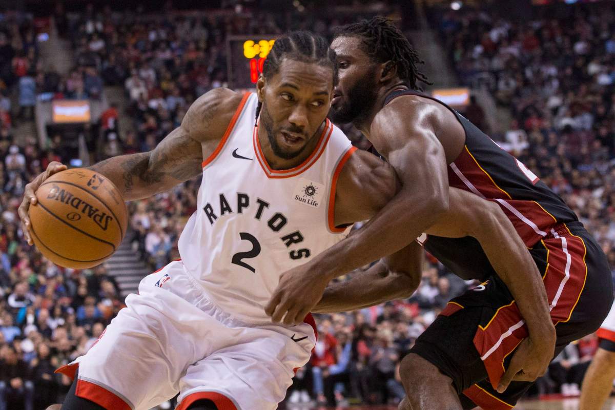 Toronto Raptors' Kawhi Leonard, left, drives at Miami Heat's Justise Winslow during first half NBA basketball action in Toronto on Sunday, November 25, 2018.