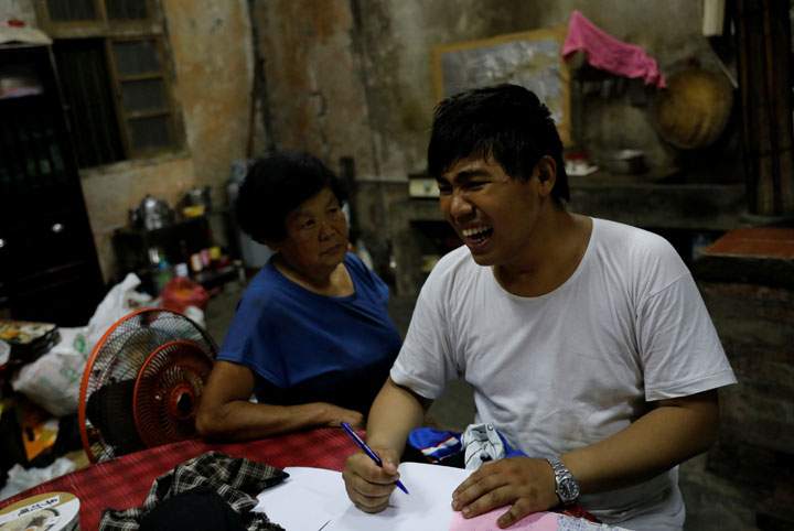 Chen Hong-zhi, 26, who suffers from short-term memory loss, quarrels with his stepmother Wang Miao-cyong, 65, while writing his notes at his home in Hsinchu, Taiwan, August 17, 2018.
