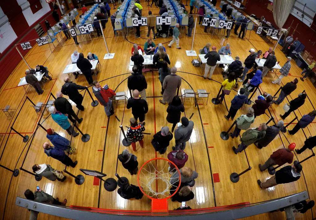 Voters wait in line in the gymnasium at Brunswick Junior High School to receive their ballots for the mid-term election, Tuesday, Nov. 6, 2018, in Brunswick, Maine. (AP Photo/Robert F. Bukaty)