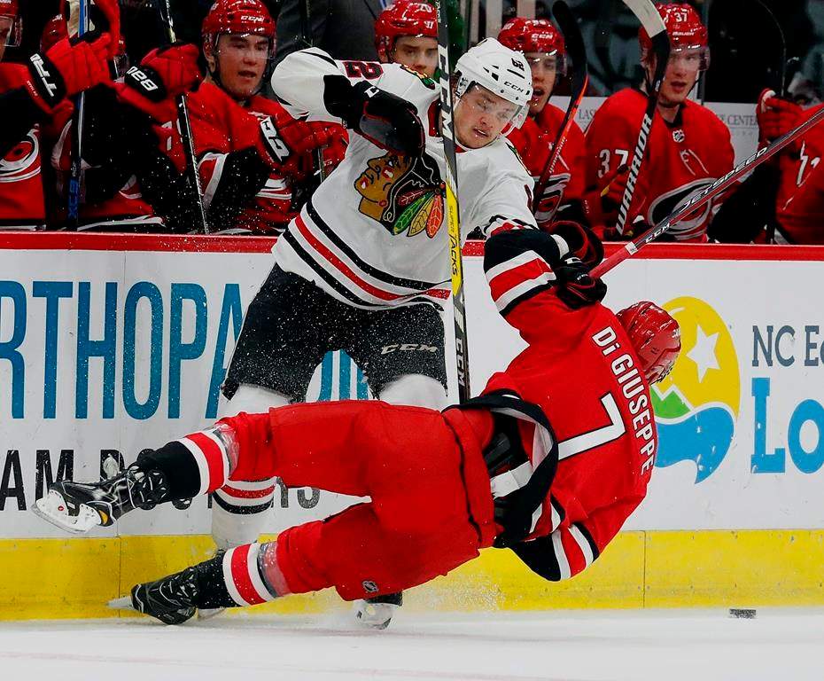 The Carolina Hurricanes’ Phillip Di Giuseppe (7) collides with the Chicago Blackhawks’ Luke Johnson (62) during the second period of an NHL hockey game, Monday, Nov. 12, 2018, in Raleigh, N.C. (AP Photo/Karl B DeBlaker)