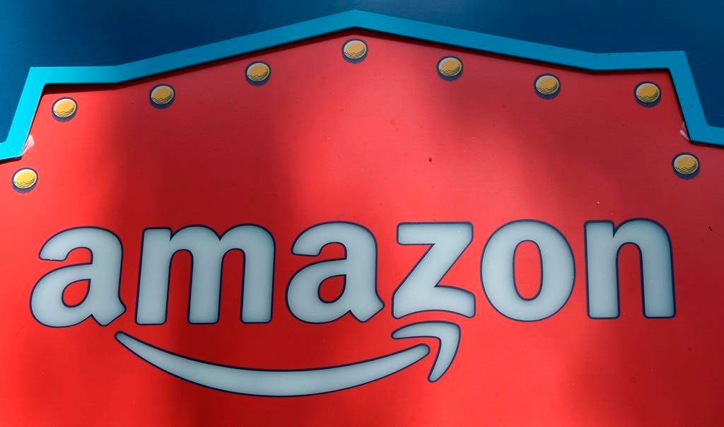 FILE - This Oct. 23, 2018, file photo shows an Amazon logo atop the Amazon Treasure Truck The Park DTLA office complex in downtown Los Angeles. Whether you've bought shoes at Zappos, picked up milk at Whole Foods or listened to an audiobook on Audible, you've been caught up in Amazon's growing web of businesses. And now, Amazon's sprawling empire will stretch even further. The company is expected to announce Tuesday, Nov. 13, that it will open two more bases outside of its Seattle headquarters: one in Crystal City in northern Virginia and the other in New York's Long Island City neighborhood. (AP Photo/Richard Vogel, File).