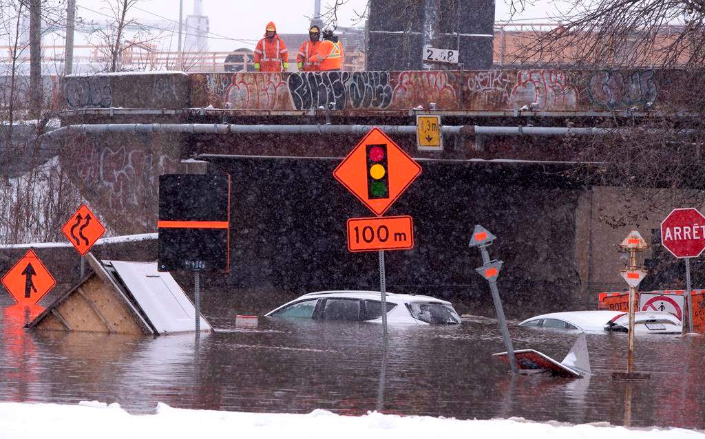 City workers look over a flooded street after a water pipe was perforated by a natural gas company doing work nearby in Montreal on Tuesday, November 20, 2018. The Atwater Tunnel, running under the Lachine Canal, was flooded cutting off a main corridor that links the downtown area to neighbourhoods to the south of the city. THE CANADIAN PRESS/Paul Chiasson