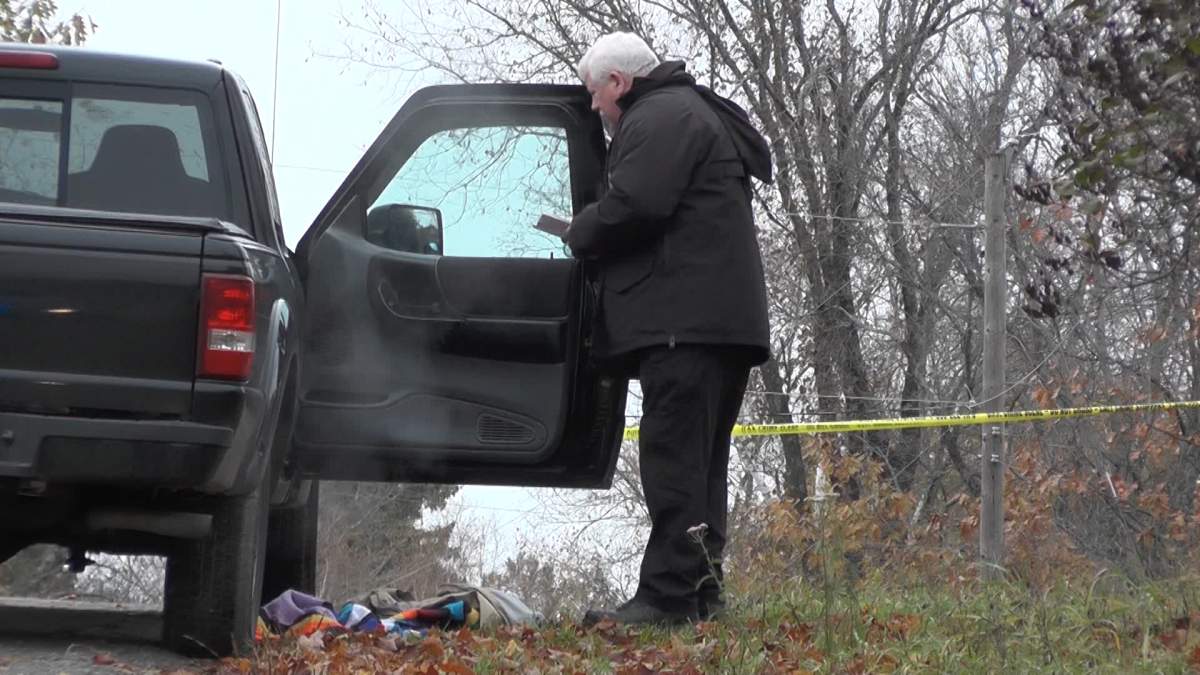 An investigator with the Special Investigations Unit reviews the scene on Tuckers Road on Thursday.