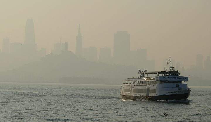 A ferry boat makes its way toward Alcatraz Island as the skyline in the background is obscured by wildfire smoke and haze Monday, Nov. 12, 2018, in San Francisco.