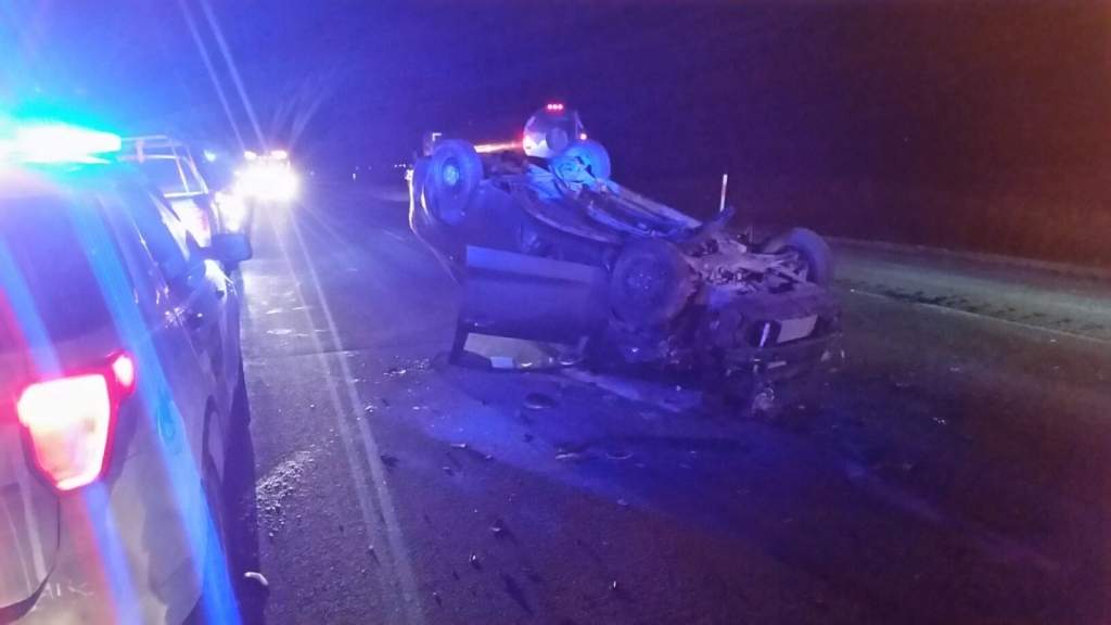 A vehicle crashed into two RCMP vehicles and then rolled on Highway 1.