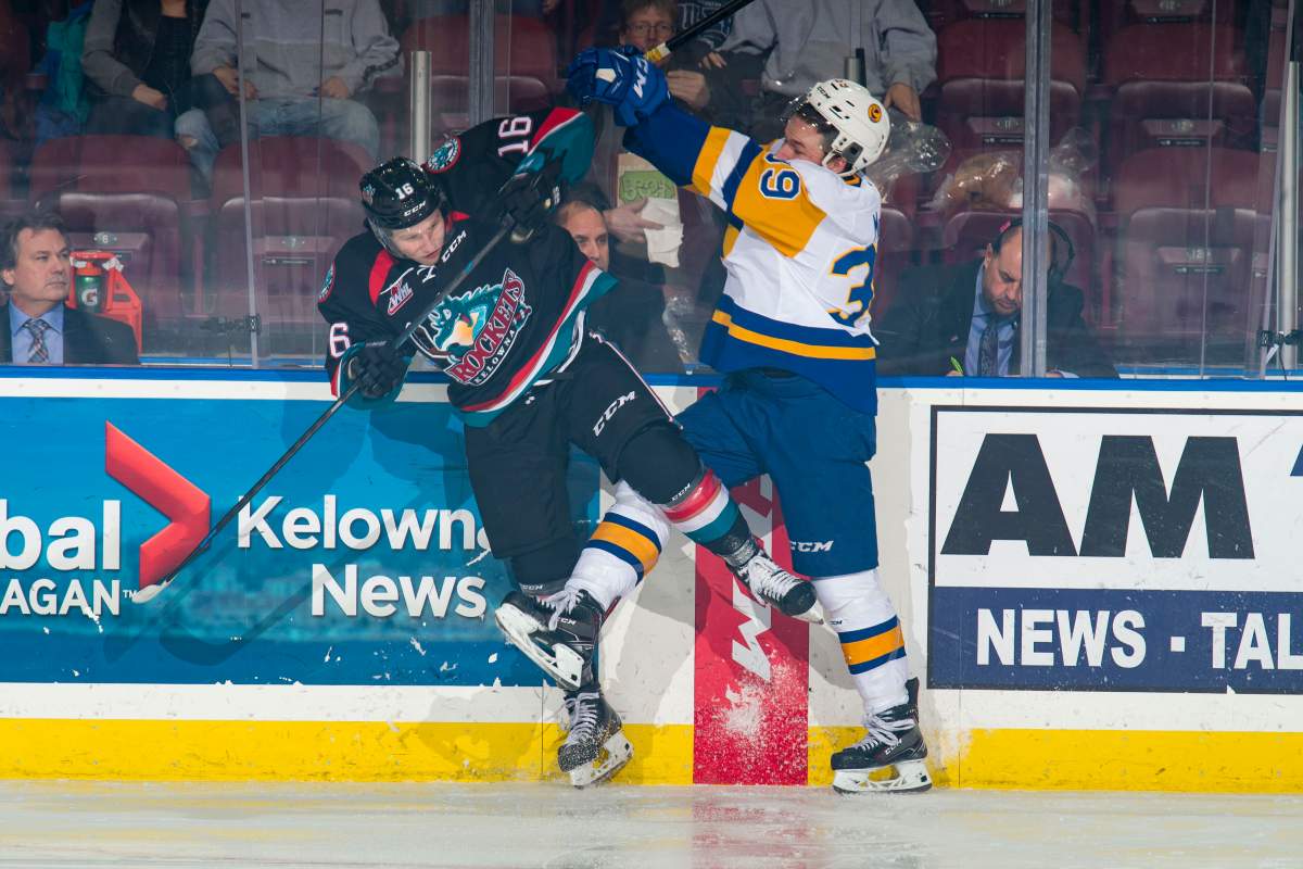 Riley McKay #39 of the Saskatoon Blades checks Michael Farren #16 of the Kelowna Rockets during first period on December 1, 2018 at Prospera Place in Kelowna.