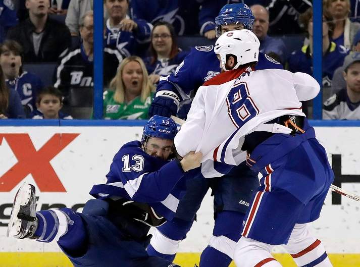 In this March 2018 file photo, Tampa Bay Lightning center Cedric Paquette (13) goes down as he fights Montreal Canadiens defenseman Jordie Benn (8) during the third period of an NHL hockey game in Tampa, Fla.