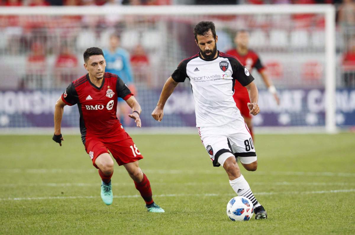 Ottawa Fury FC's Cristian Portilla battles for the ball with Toronto FC's Marco Delgado, left, during the first half of Canadian Championship soccer action in Toronto, Wednesday July 25, 2018.
