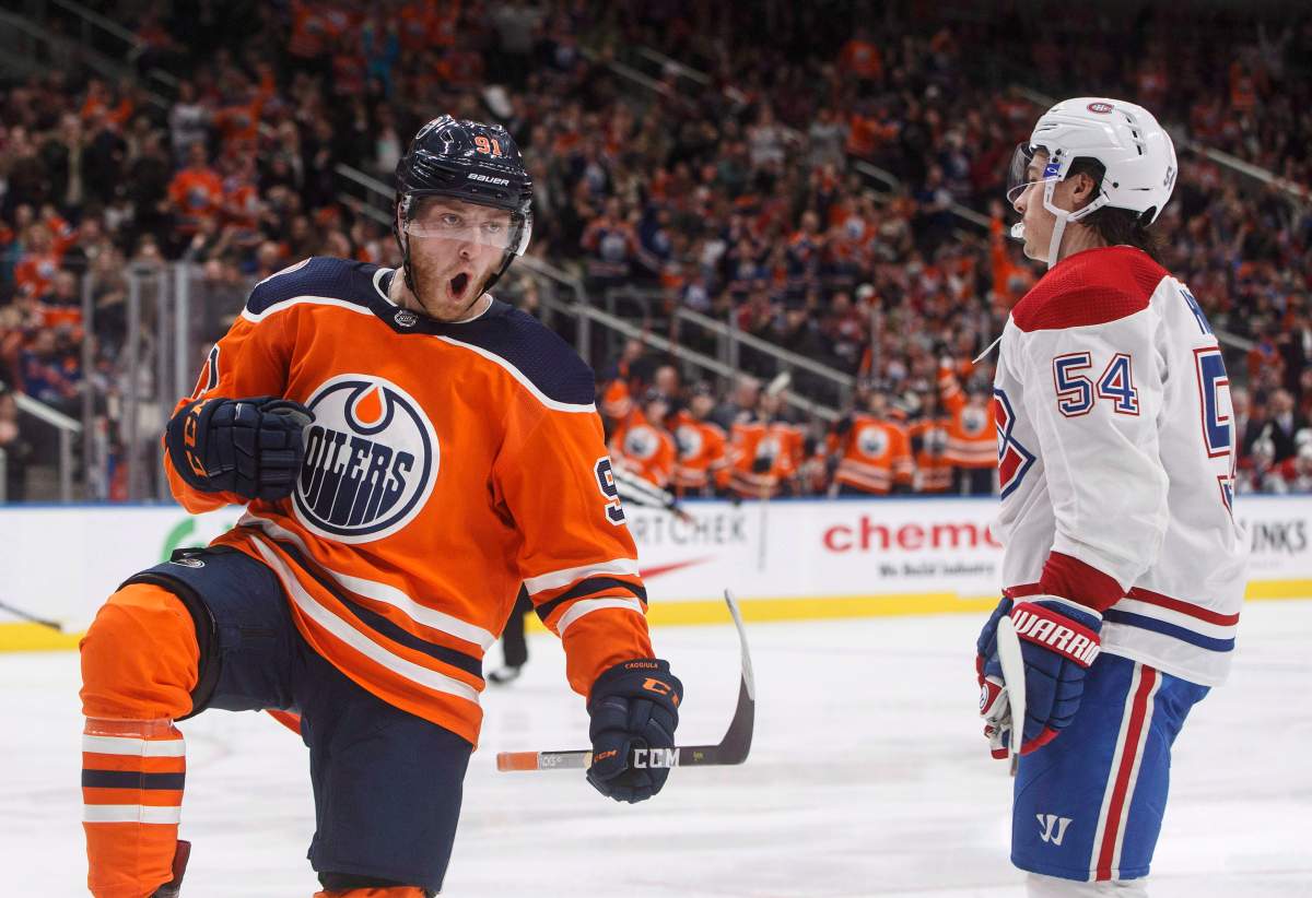 Montreal Canadiens' Charles Hudon (54) skates past as Edmonton Oilers' Drake Caggiula (91) celebrates a goal during second period NHL action in Edmonton, Alta., on Tuesday November 13, 2018. THE CANADIAN PRESS/Jason Franson.