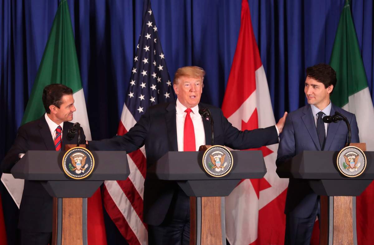 President Donald Trump, center, reaches out to Mexico's President Enrique Pena Nieto, left, and Canada's Prime Minister Justin Trudeau as they prepare to sign a new United States-Mexico-Canada Agreement that is replacing the NAFTA trade deal, during a ceremony at a hotel before the start of the G20 summit in Buenos Aires, Argentina, Friday, Nov. 30, 2018.