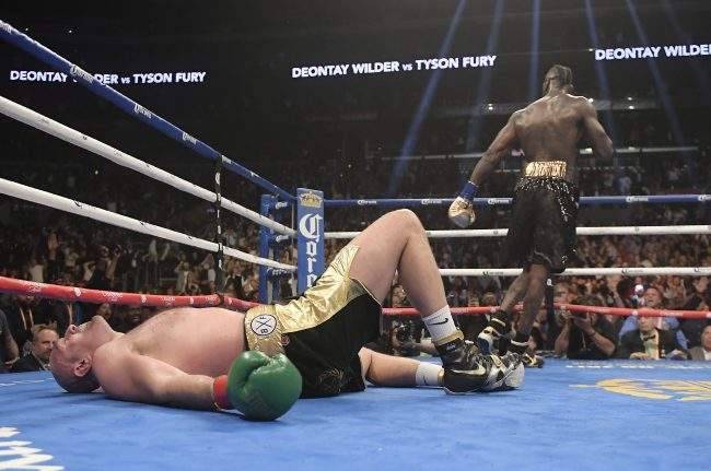 Tyson Fury lies on the canvas after being knocked down by Deontay Wilder during the 12th round of a WBC heavyweight championship boxing match Saturday, Dec. 1, 2018, in Los Angeles.