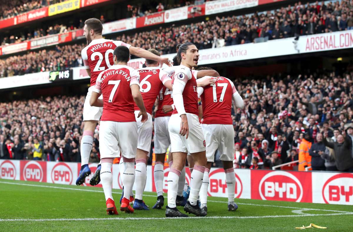 Arsenal’s Pierre-Emerick Aubameyang celebrates scoring his side’s first goal of the game from the penalty spot with teammates, as a banana skin is thrown onto the pitch during the English Premier League soccer match at Emirates Stadium, London, Sunday, Dec. 2, 2018. A Tottenham supporter was arrested for throwing a banana skin onto the field after Aubameyang scored and celebrated in front of away fans.