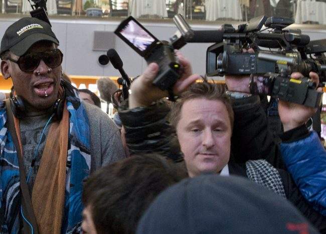 FILE – In this Dec. 19, 2013, file photo, Michael Spavor, center, an entrepreneur, is seen with former NBA star Dennis Rodman, left, on the arrival at the capital airport for a flight to North Korea, in Beijing, China.