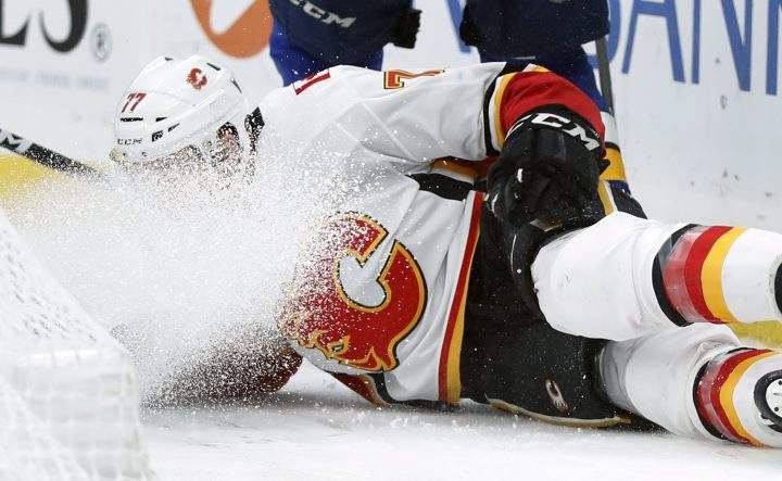Calgary Flames’ Mark Jankowski has ice sprayed in his face as he falls during the third period of an NHL hockey game against the St. Louis Blues, Sunday, Dec. 16, 2018, in St. Louis.