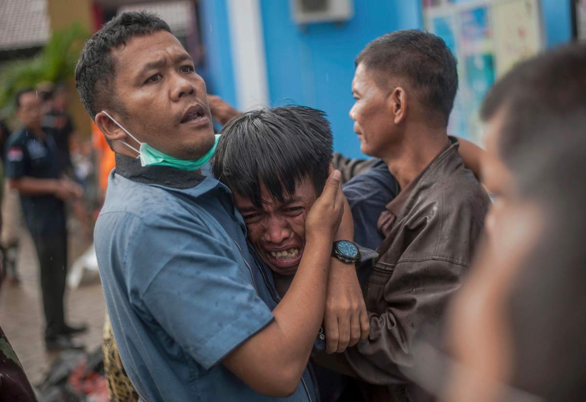 A man reacts after identifying his relative among the bodies of tsunami victims in Carita, Indonesia, Sunday, Dec. 23, 2018.