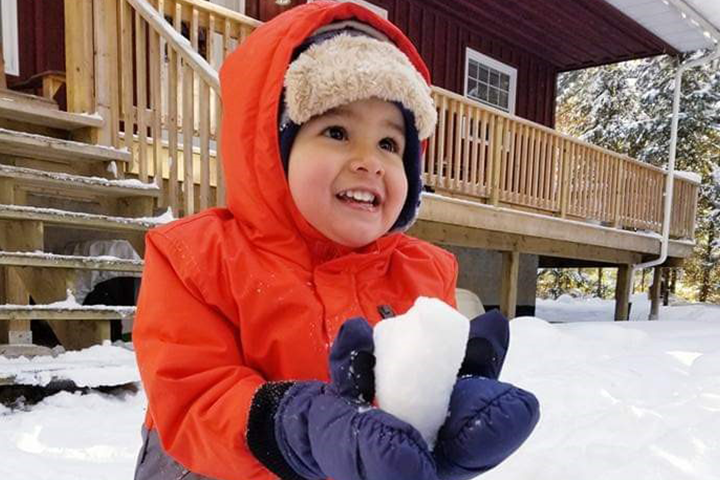 Three-year-old Thomas Montoya playing in snow.