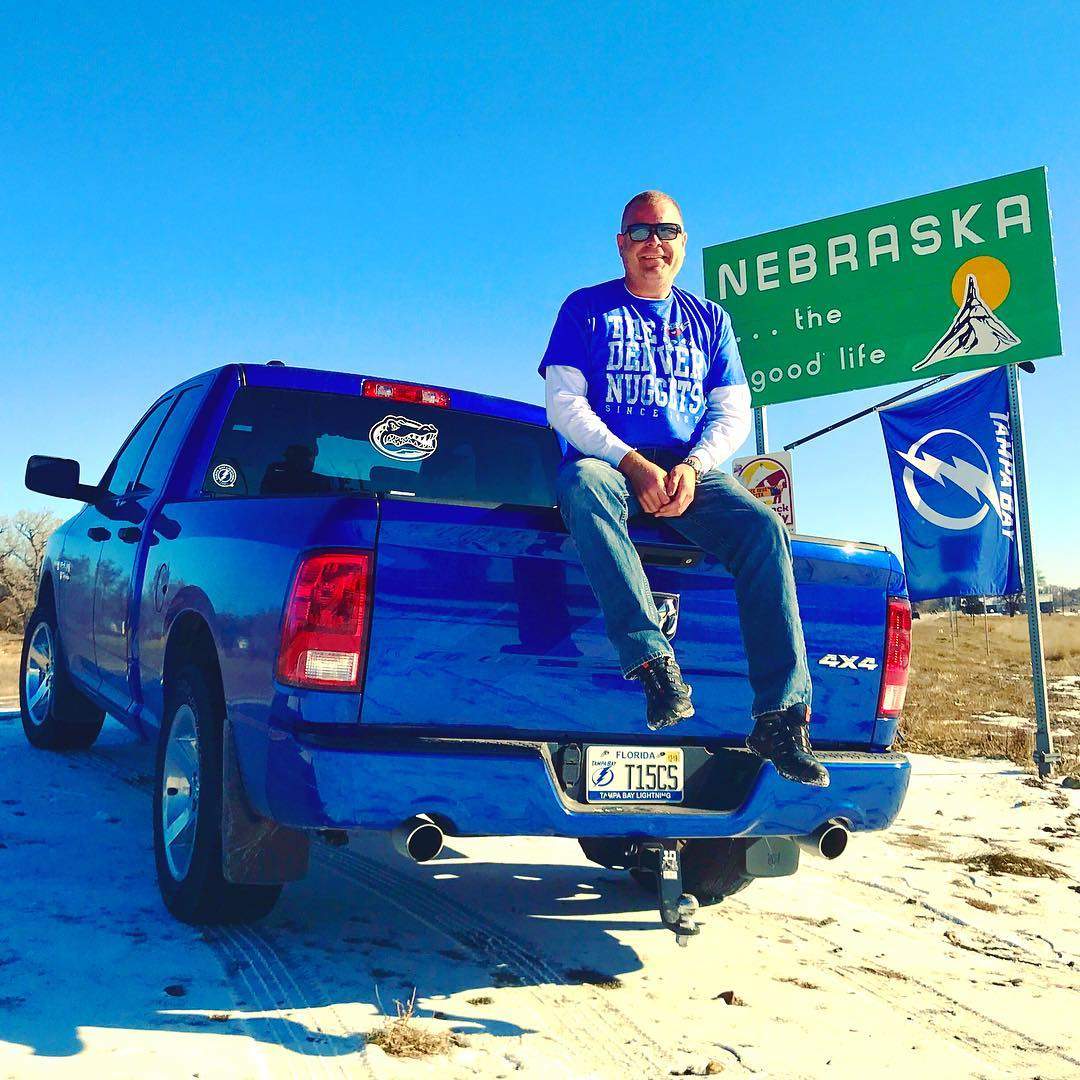 Adam Vosding hanging out at the “Welcome to Nebraska” sign during his trek up to Winnipeg.
