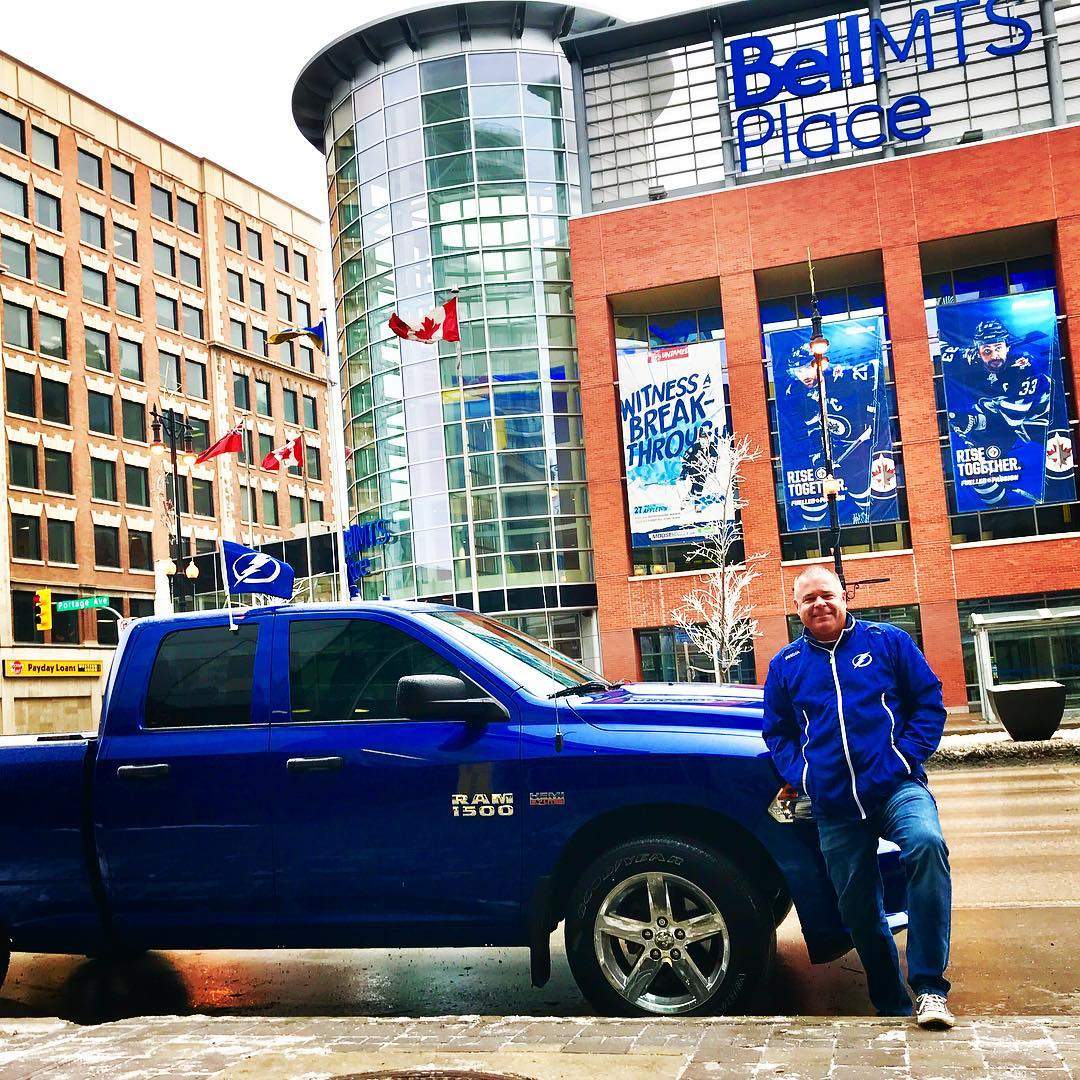 Vosding standing outside Bell MTS Place with his truck suiting Tampa Bay Lightning flags on both sides.