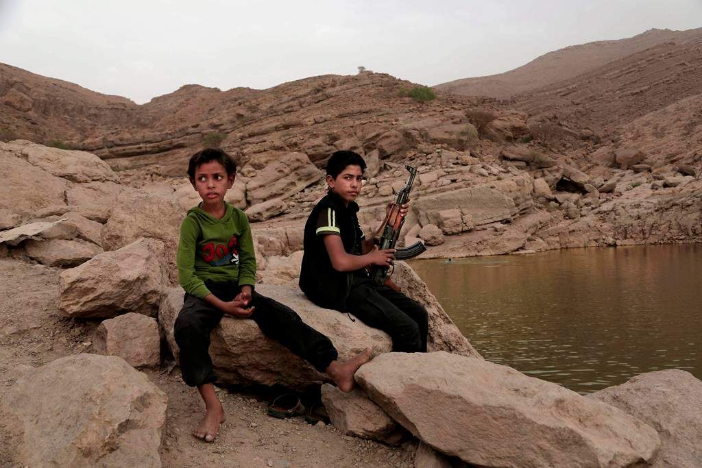 In this July 30, 2018, photo, a 17 year-old boy holds his weapon in High dam in Marib, Yemen.
