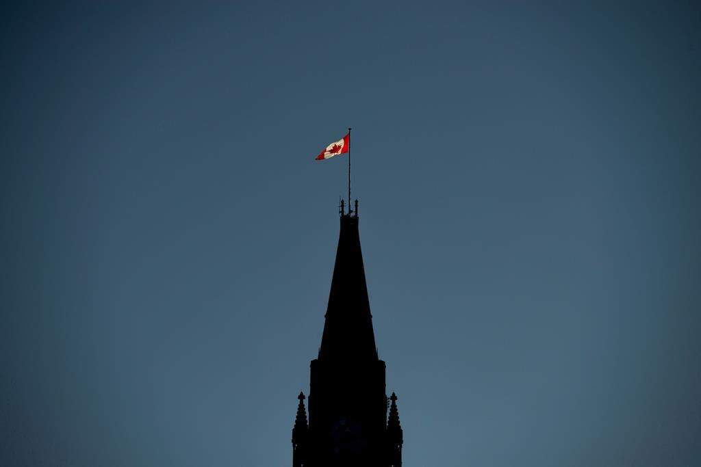 Ottawa ran a small surplus of $92 million through the first seven months of its fiscal year, compared with a deficit of nearly $6.6 billion in the same period last year as revenue has increased faster than spending. The Canadian Flag is illuminated by morning light atop the Peace Tower on Parliament Hill in Ottawa on Monday, Sept. 17, 2018.