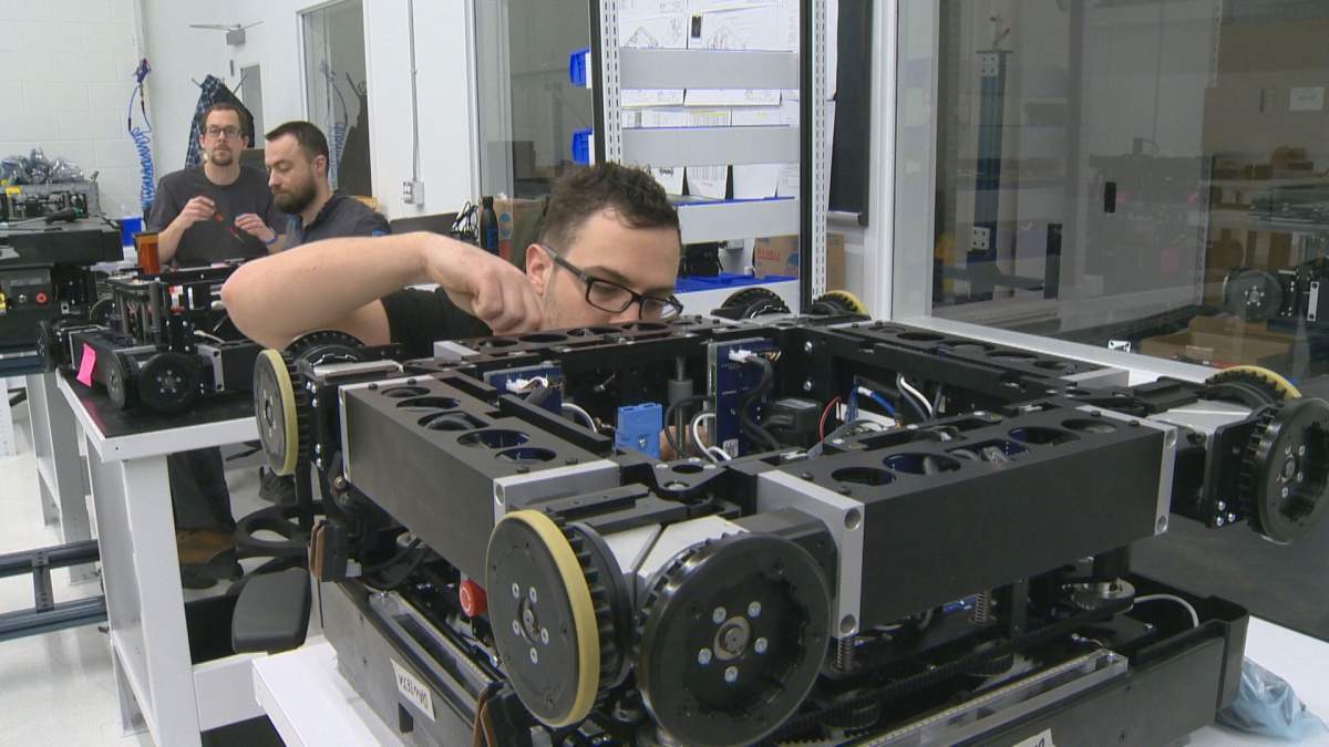 An ATTAbotics technician works on a robot on Dec. 12, 2018.