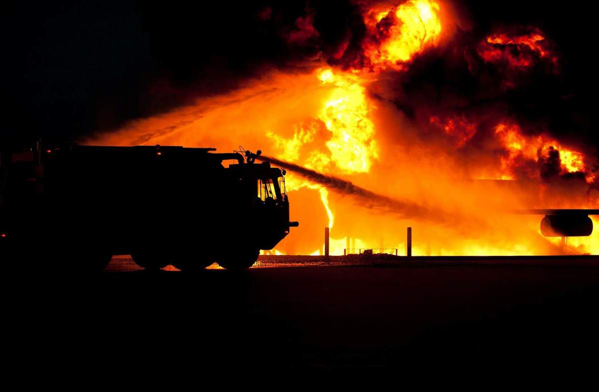 A fire truck pours water on a burning building.