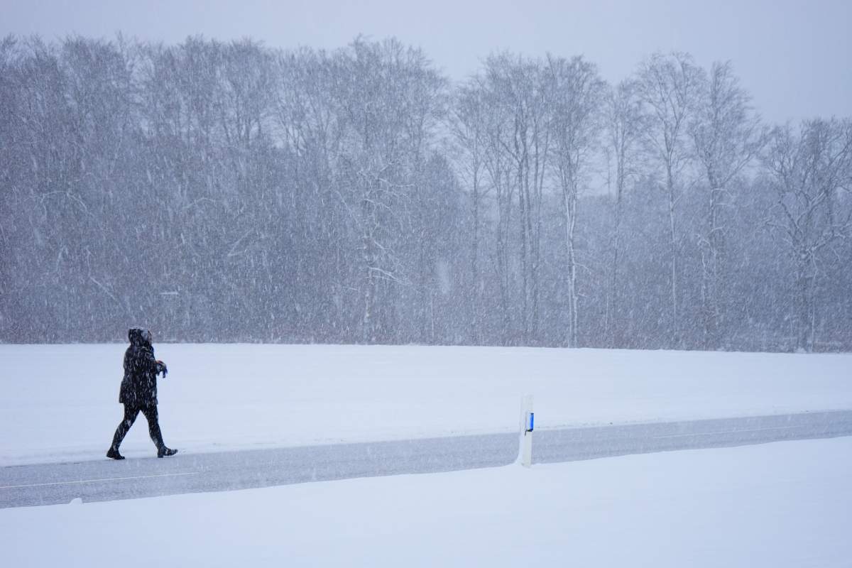 A woman walks on a snowy day.
