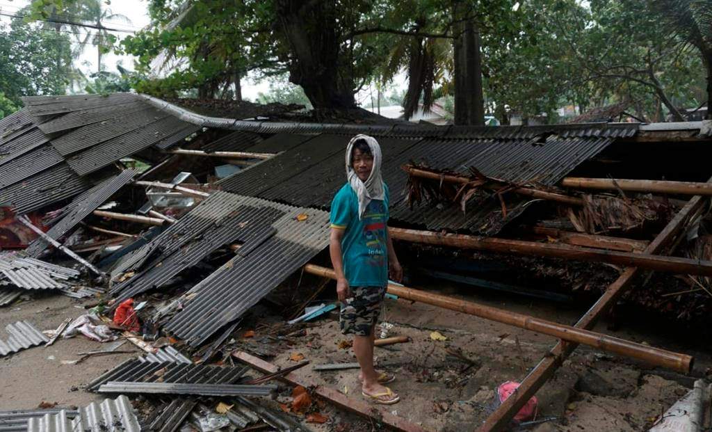 A man inspects his house which was damaged by a tsunami, in Carita, Indonesia, Sunday, Dec. 23, 2018.