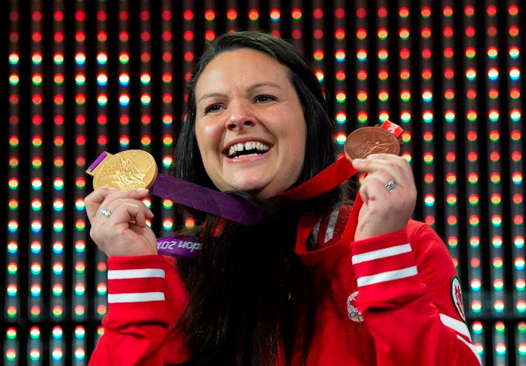 Canadian weightlifter Christine Girard holds up the gold and bronze Olympic medals she was awarded during a ceremony Monday December 3, 2018 in Ottawa. Girard was awarded the London 2012 gold and Beijing 2008 bronze medals after the International Olympic Committee disqualified athletes from the 2008 and 2012 Olympic games.