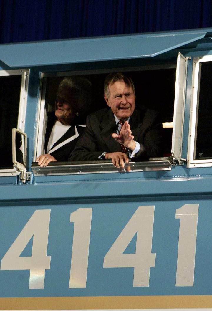 In this Oct. 18, 2005, file photo, former President George H.W. Bush and his wife Barbara wave out the window of a new locomotive numbered 4141 in honor of the 41st president at Texas A&M University in College Station, Texas.