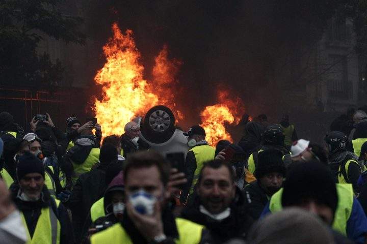 Cars burn as protesters wearing yellow vests (gilets jaunes) clash with riot police near the Arc de Triomphe as part of a demonstration over high fuel prices on the Champs Elysee in Paris, France, 01 December 2018.