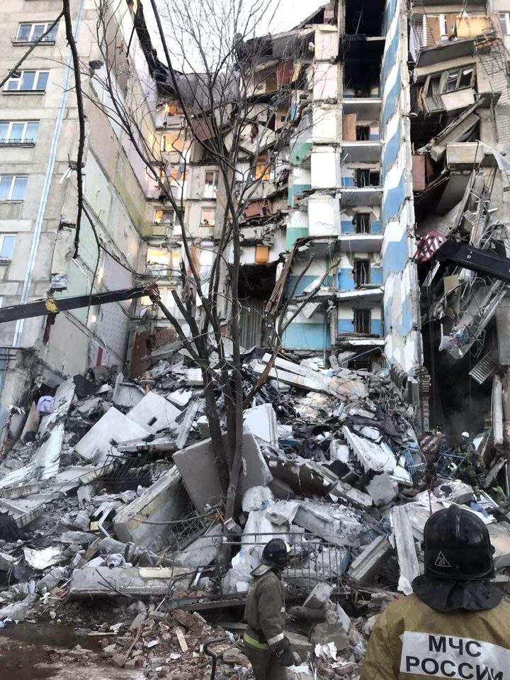 This image provided by the Russian Emergency Situations Ministry taken from TV footage, shows Emergency Situations employees working at the scene of a collapsed section of an apartment building in Magnitogorsk, Russia, Monday, Dec. 31, 2018.