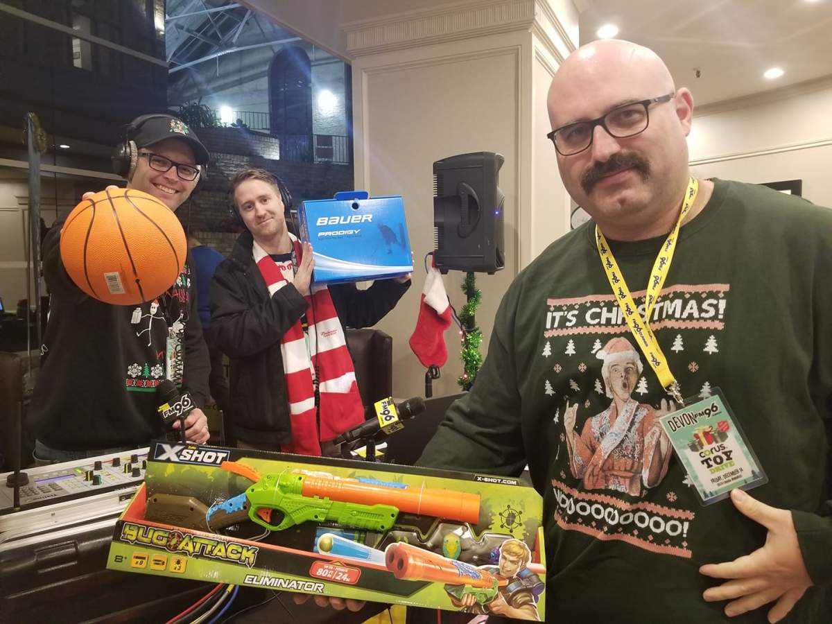 Taz, Jim, and Devon Peacock from The Taz Show on FM96 show off some of the toys already collected during Corus Radio London's sixth annual Drive-Thru Toy Drive at the Delta Armouries.
