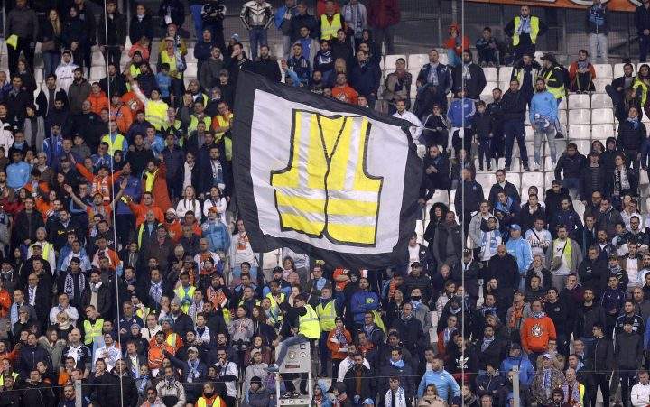 A supporter of Marseille waves a flag representing a giant yellow jacket, in solidarity with the movement of the demonstrators, called yellow jackets, who protest against the rising of fuel taxes, during the League One soccer match between Marseille and Reims at the Velodrome stadium, in Marseille, southern France, Sunday, Dec. 2, 2018.