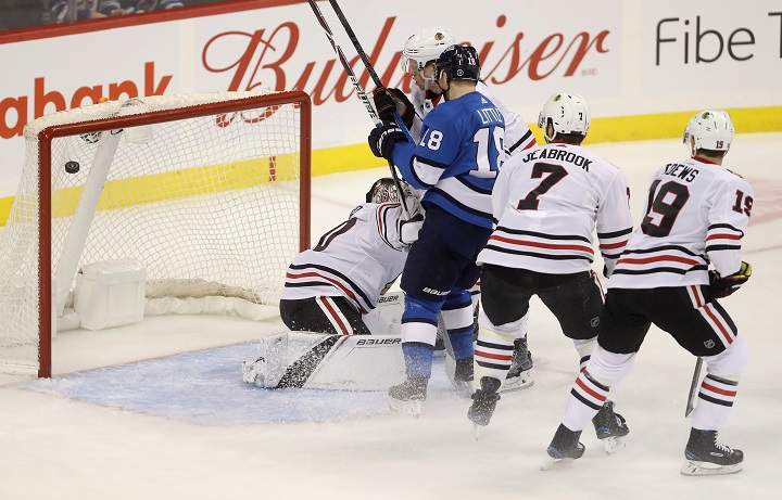 A shot by Winnipeg Jets' Kyle Connor (81), not shown, beats Chicago Blackhawks' goaltender Cam Ward (30) with Bryan Little (18) battling Connor Murphy (5), Brent Seabrook (7), and Jonathan Toews (19) in front of the net during first period NHL hockey action in Winnipeg, Tuesday, December 11, 2018. 