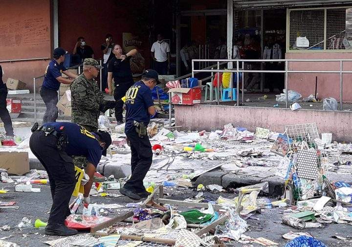 Members of the Philippine National Police Scene of the Crime Operatives gather evidence at the site of an explosion on New Year’s Eve outside a shopping mall in Cotabato City, southern Philippines, Dec. 31, 2018.