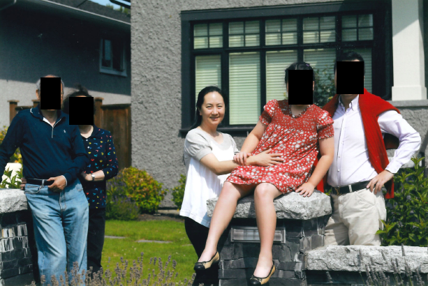Meng Wanzhou with family in front of a home.