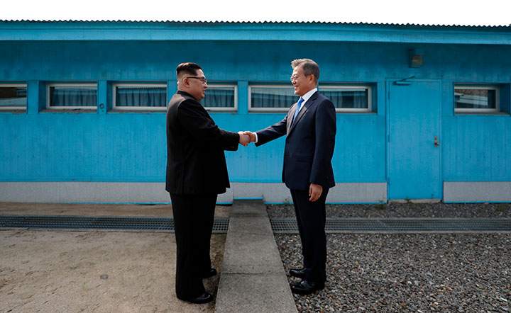 North Korea’s leader Kim Jong Un shakes hands with South Korea’s President Moon Jae-in at the Military Demarcation Line that divides their countries at the truce village of Panmunjom on April 27, 2018.