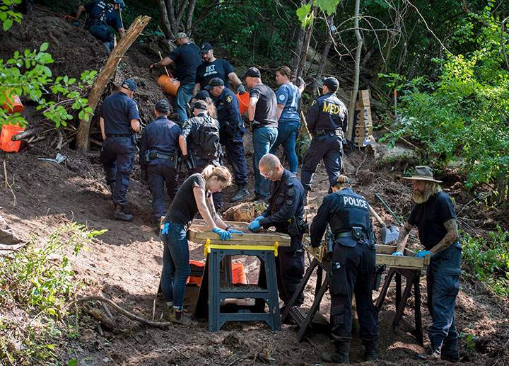 Members of the Toronto Police Service sift and excavate materials from the back of property along Mallory Cres. in Toronto after confirming they have found human remains during an investigation in relation to alleged serial killer Bruce McArthur on Thursday, July 5, 2018.