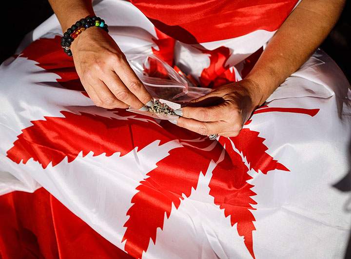 A cannabis user rolls a joint at a rally outside government offices following the legalization of cannabis in Calgary, Alta., Oct. 17, 2018.