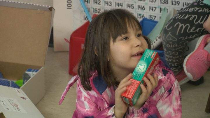 Princess Alexandra student holds up the toothpaste she received in her shoe box.