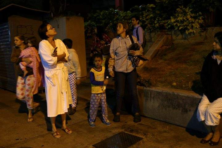 People stand on the street after an earthquake was felt across northern Venezuela, in Caracas, Venezuela December 27, 2018. 