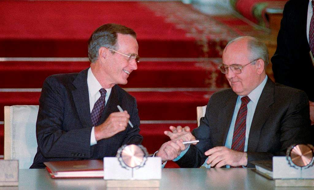 In this file photo taken Aug. 1, 1991, U.S. President George H.W. Bush and Soviet President Mikhail Gorbachev exchange pens after signing the START arms reduction treaty in the Kremlin, Moscow. (AP Photo/Boris Yurchenko)