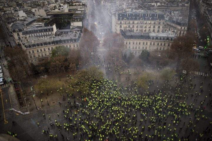 A view shows a barricade with police forces and protesters wearing yellow vests, a symbol of a French drivers protest against higher diesel taxes, during clashes as part of a demonstration near the Place de l’etoile in Paris, France, December 1, 2018.