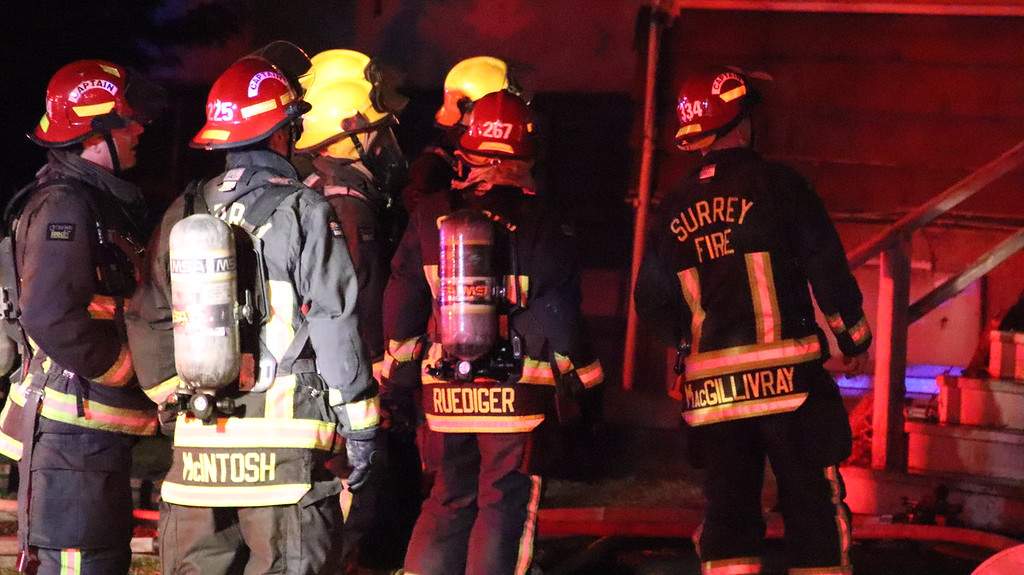 Surrey crews work to knock down a fire in a duplex in Whalley on Thursday.