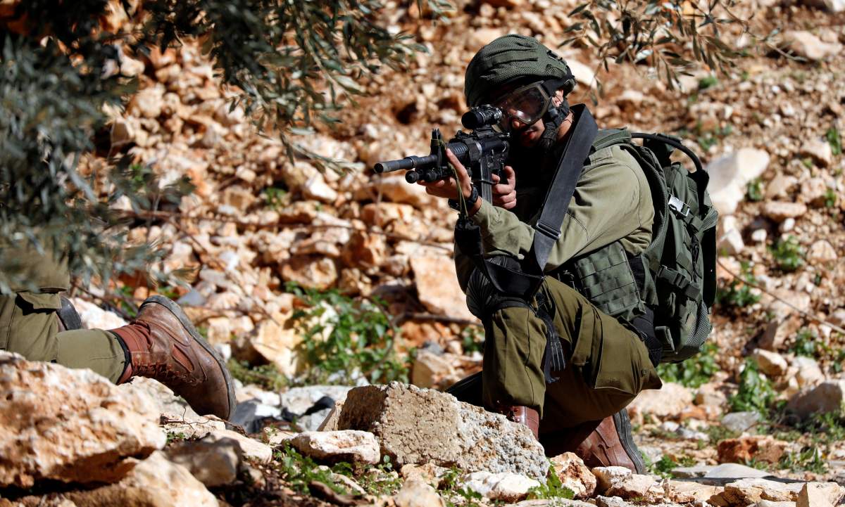 An Israeli soldier aims his weapon during clashes with Palestinians at a protest near Nablus in the Israeli-occupied West Bank January 4, 2019. 