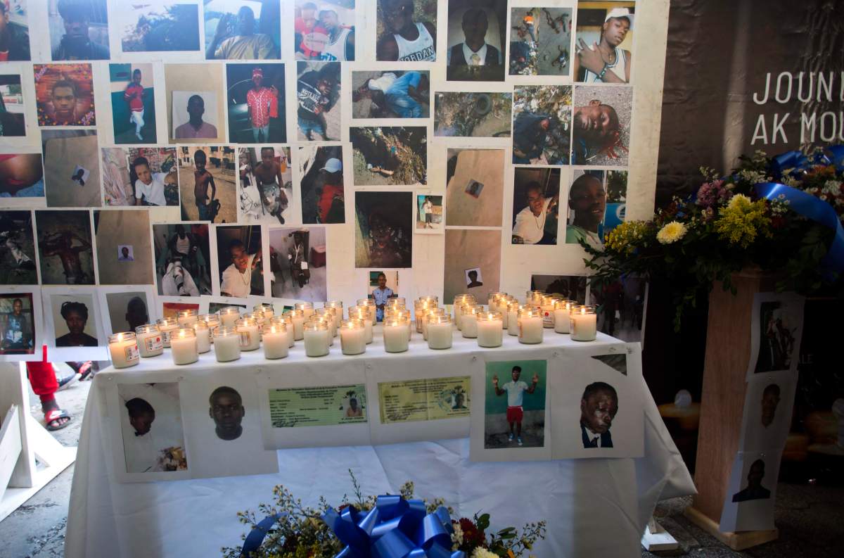 In this Dec. 13, 2018, photo, pictures, candles and flowers decorate an altar for the massacre victims during a memorial in the La Saline slum of Port-au-Prince, Haiti.